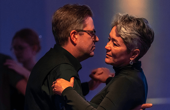 Älteres Paar tanzt eng in gedämpftem Licht bei einer Veranstaltung im Innenraum