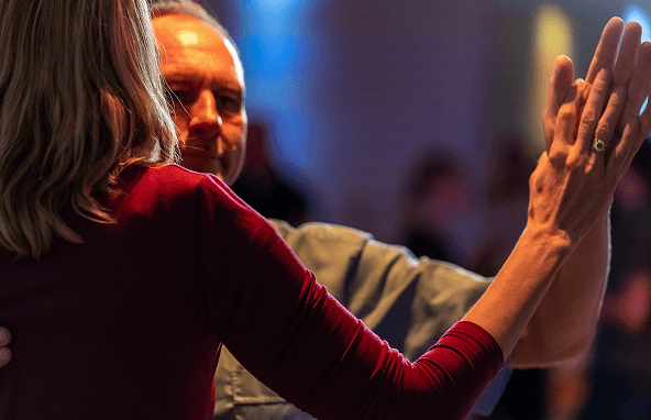 Paar tanzt eng zusammen in gedämpfter Beleuchtung bei einer Tanzveranstaltung oder Party