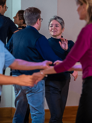 Mehrere Menschen beim Tanzkurs in einem hellen Raum in legerer Kleidung und entspannter Atmosphäre