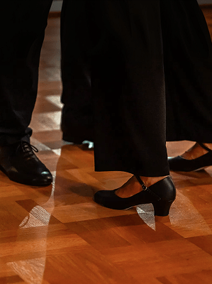 Schwarze Tanzschuhe von Paar auf Parkettboden während Tanzveranstaltung