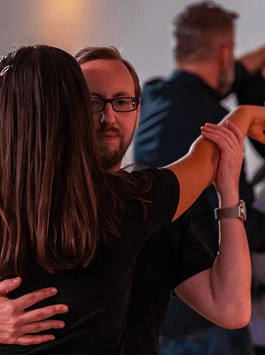 Paar beim Paartanz in Innenraum mit gedämpftem Licht und entspannter Atmosphäre