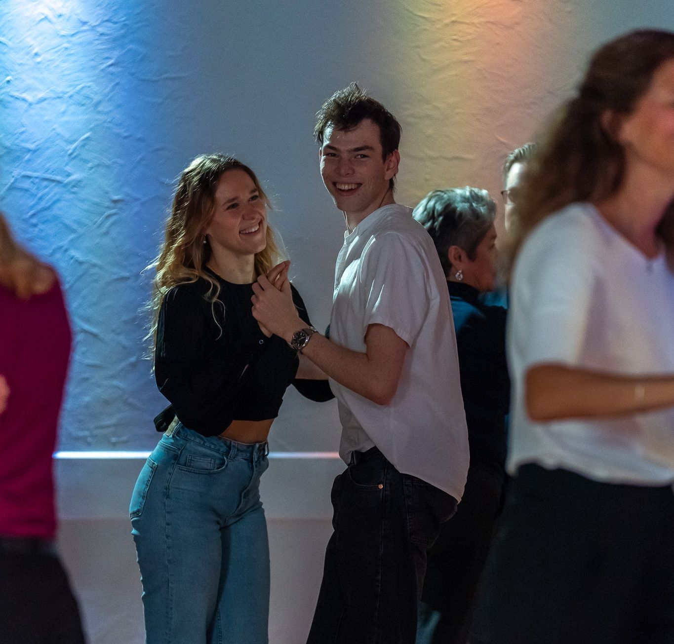 Zwei Personen tanzen entspannt miteinander auf der Tanzfläche und lächeln