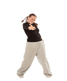 Junge Frau mit schwarzem Pullover und grauer Jogginghose macht Fingerpistole-Geste und lächelt