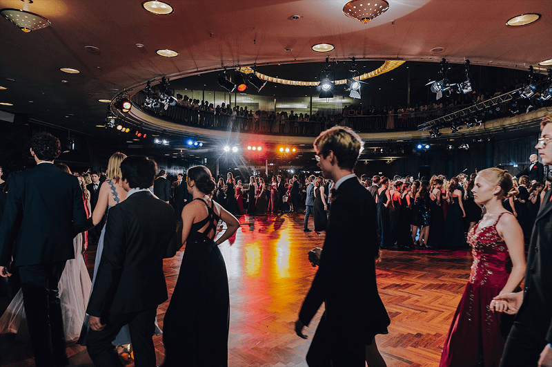 Eleganter Ballabend mit Tanzpaaren und festlicher Atmosphäre in einem großen Tanzsaal